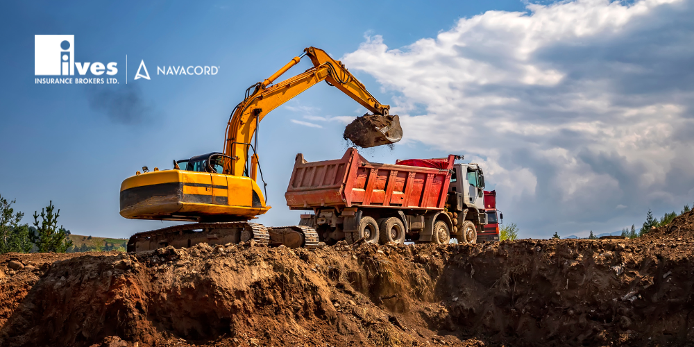 An excavator digging the foundation of a home, lifting soil and emptying it into a nearby dump truck at an active construction site.